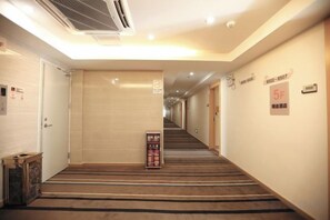 A hotel hallway with carpeted stairs, a vending machine, and a sign indicating room number 5F. - YX Our Inn (Guangzhou)