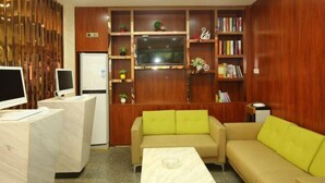 A modern living room with a sofa, a coffee table, a TV, and a bookshelf.