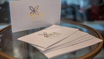A glass table with a stack of business cards and a card with 'NICE LIVING' branding.