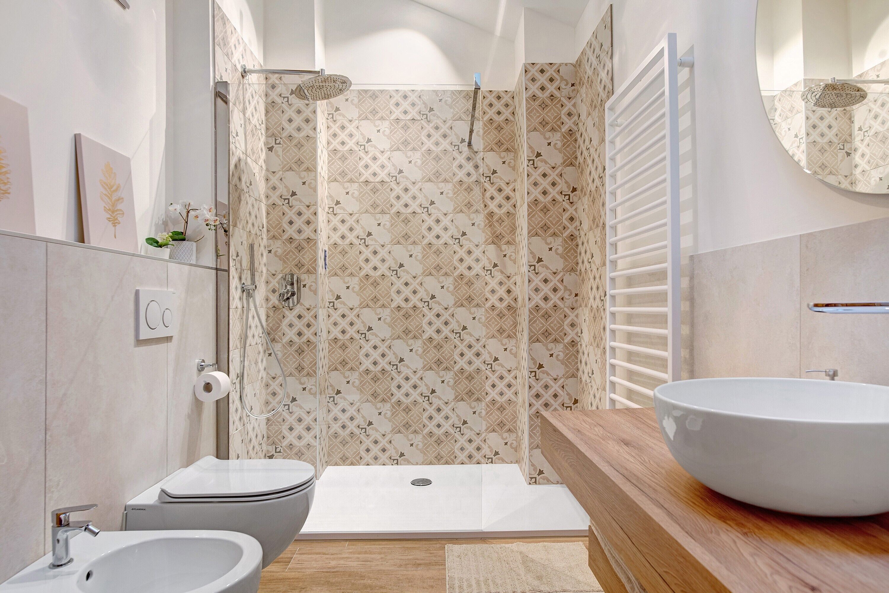 Un bagno moderno con doccia, WC, bidet e un ampio lavandino.
