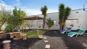 A patio with a pergola, outdoor seating, and a small garden area. - Finca Fani 4 with Mountain Views, Shared Pool, Wi-Fi, Terrace & Garden (Agüimes)