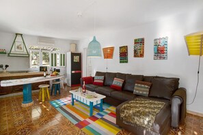 A living room with a sofa, coffee table, and colorful rug.