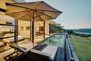A modern hotel room with a private pool, lounge chairs, and a large umbrella. - Maua Nusa Penida (Penida Island)