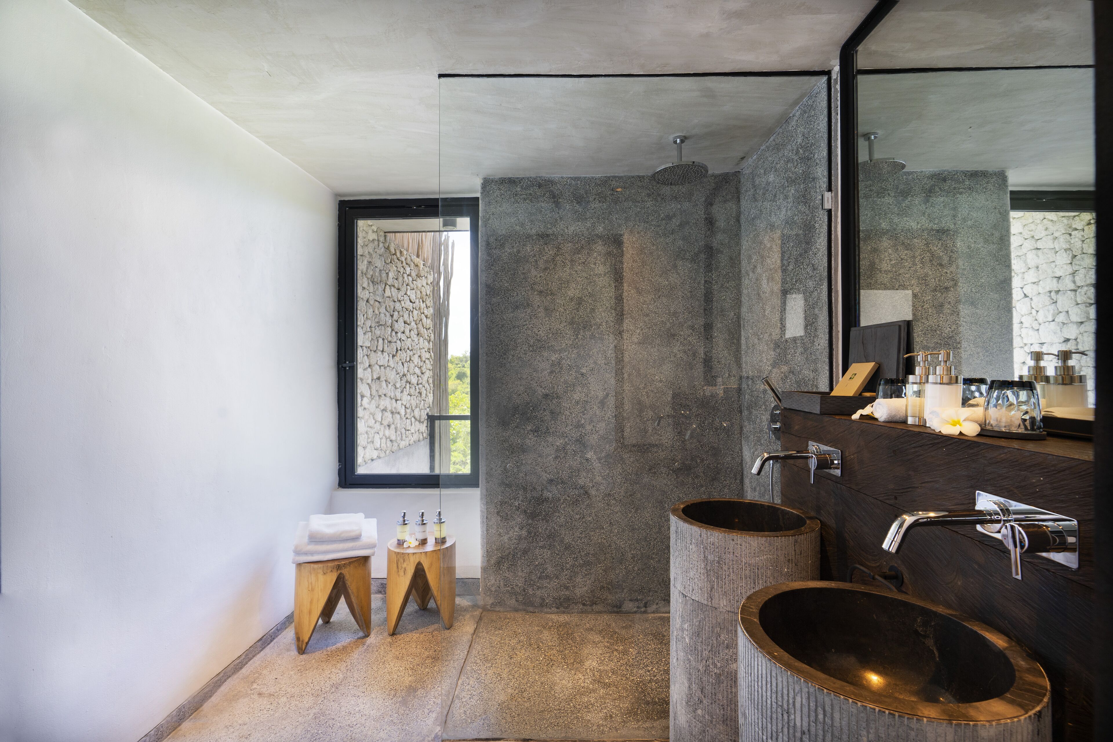 A modern bathroom with two large sinks, a large mirror, and a window with a view.