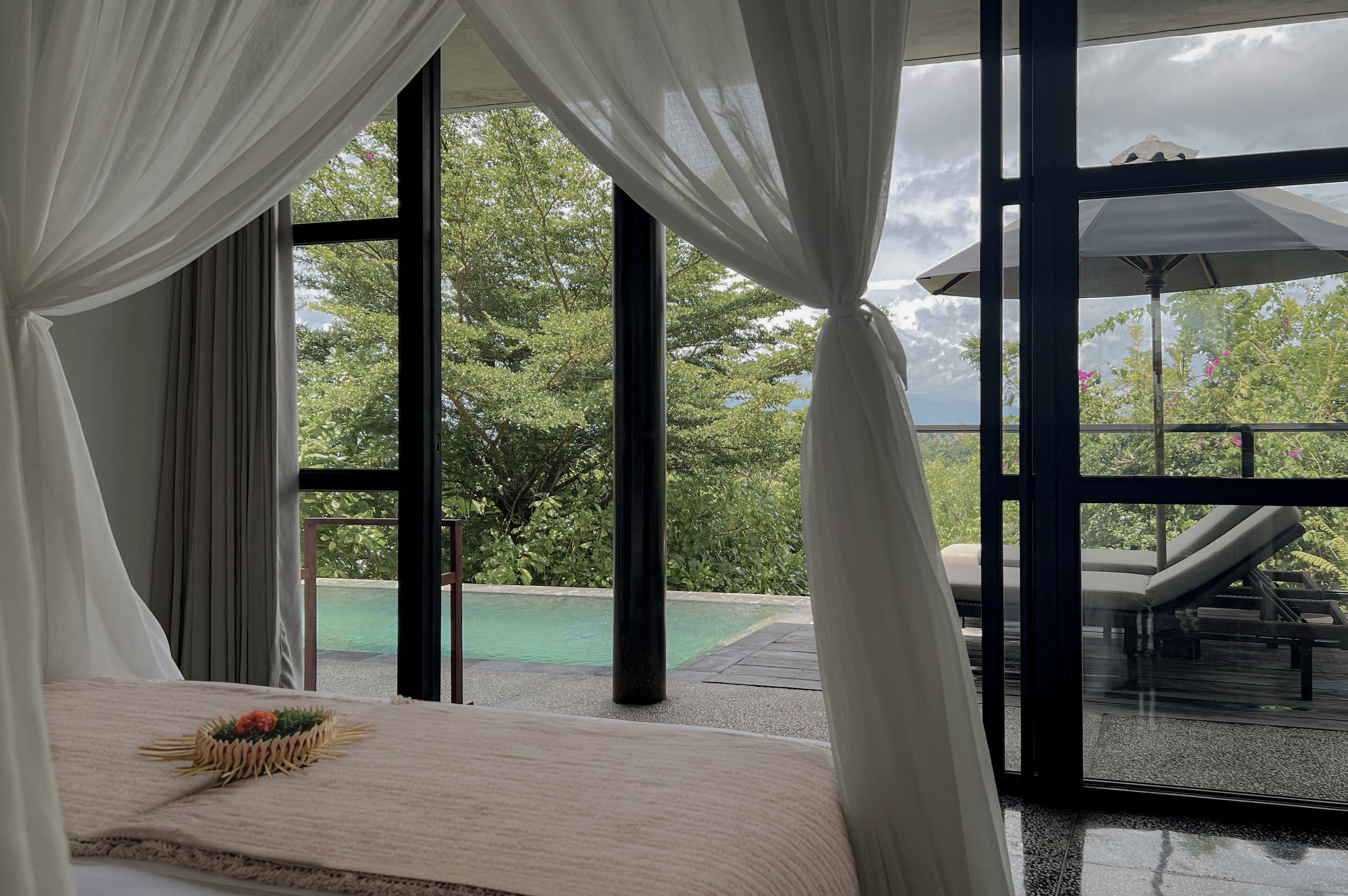Une chambre avec vue sur une piscine extérieure et un espace de détente.