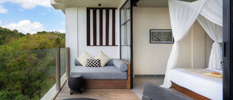 Un balcon avec un lit, un canapé et une table avec des livres.