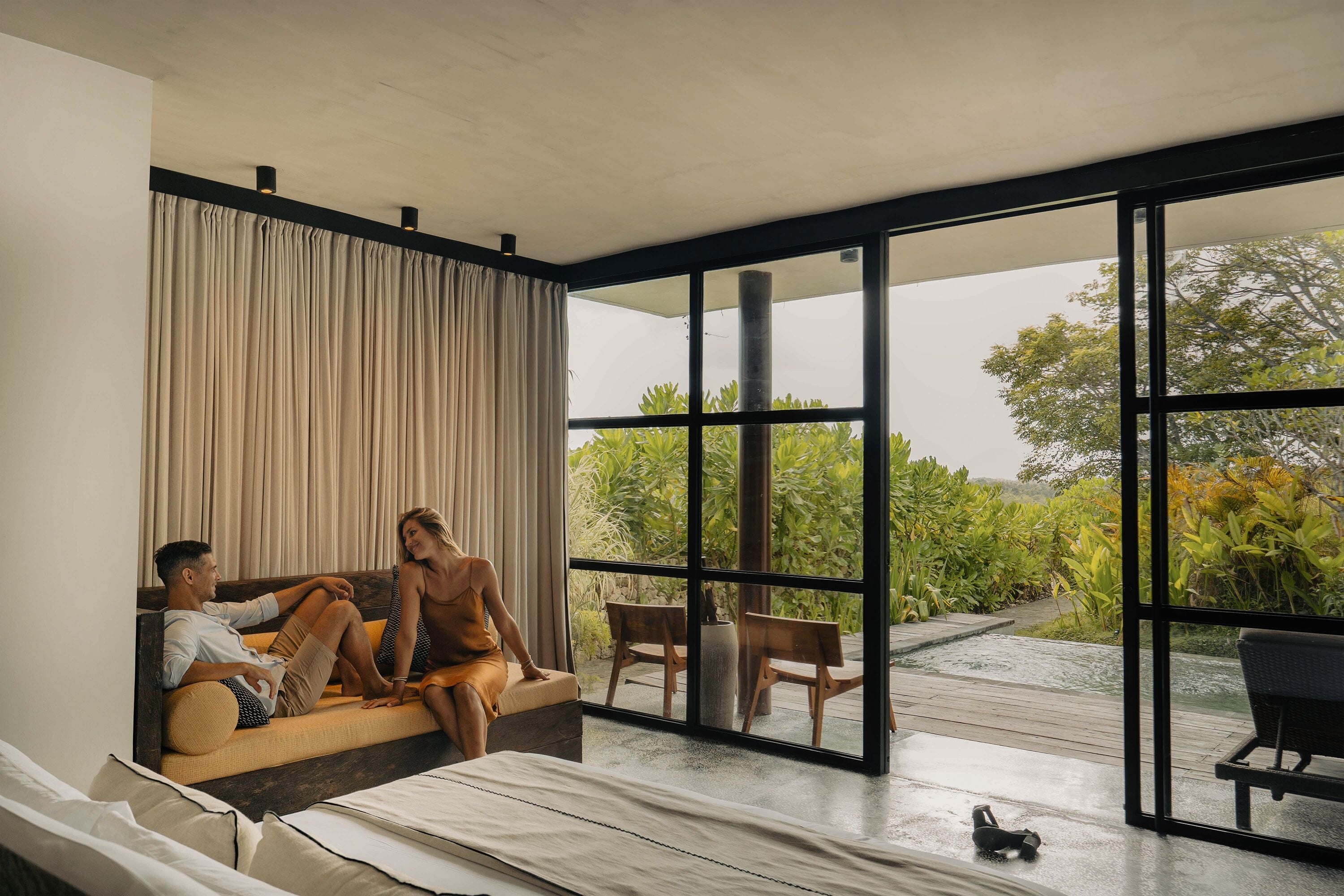 A modern room with a large window, a sofa, and a small table.