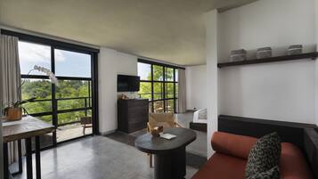 Una habitación moderna con un ventanal grande, un sofá, una mesa y un televisor.