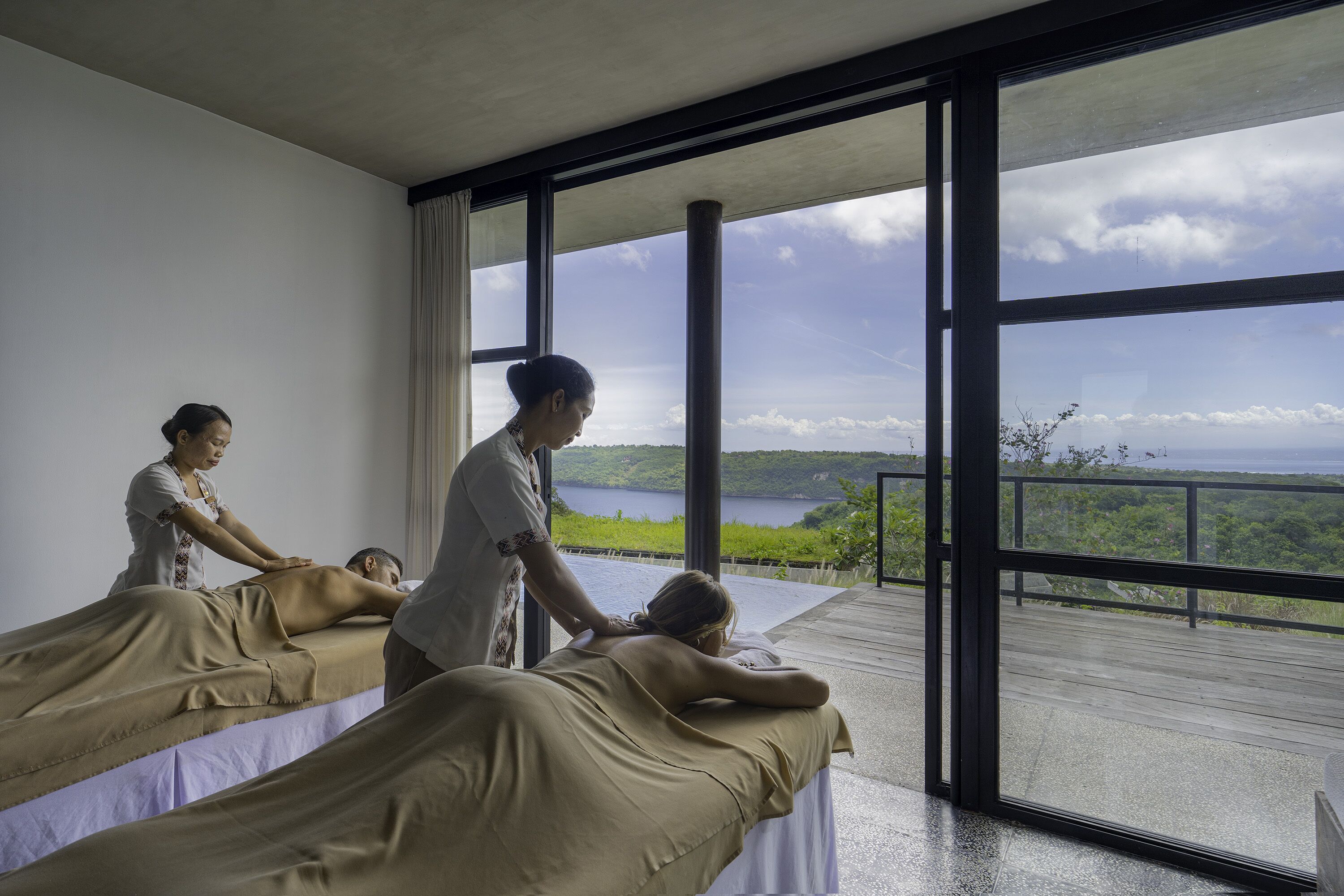 Une salle de massage équipée de deux tables de massage et dotée d’une grande fenêtre donnant sur un paysage magnifique.