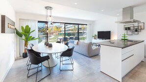 Una cocina moderna con comedor, ventanas amplias y vistas al exterior.