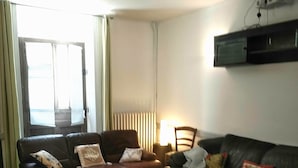 A living room with two leather sofas, a green armchair, and a patterned rug. - Family home in the country (groslee saint benoit)