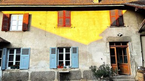 A building with a yellow facade, blue shutters, and a tiled roof. - Family home in the country (groslee saint benoit)
