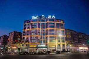 Un hotel de varios pisos con una señalización llamativa en la parte superior.