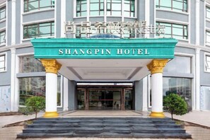 The entrance to the Shangpin Hotel with a prominent sign, a covered entrance, and a staircase leading up to the door. - ShangPing xifeng Hotel (Xinfeng)