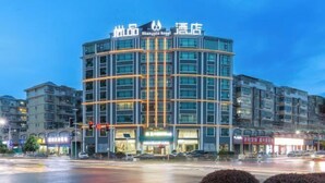 Un hotel moderno con fachada curva, varios pisos y señalización iluminada.