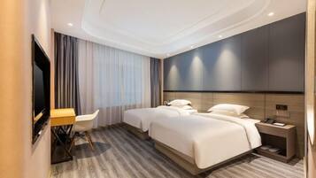 A modern hotel room with a large bed, a desk, and a TV.
