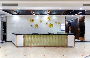Un área de recepción con diseño moderno, que incluye un mostrador de recepción, paneles decorativos en la pared y un piso estampado.