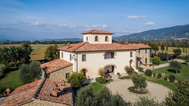 A white building with a red-tiled roof, arched windows, and a central tower. - Timeless Tuscan Holiday Stay (Unknown)