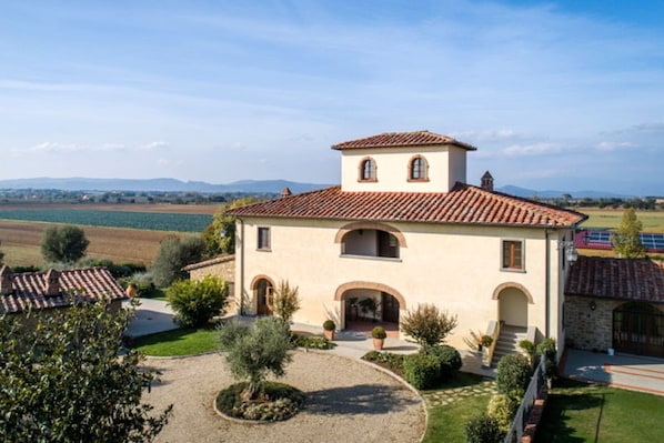 Stunning Mediterranean villa with a central tower, arched windows, and beautifully maintained gardens.