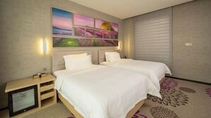 A hotel room with two beds, a large wall art piece, a flat-screen TV, and a patterned carpet. - Lavande Hotel (Dongguan)