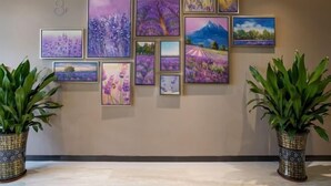 A wall with multiple framed artworks depicting landscapes and flowers. - Lavande Hotel (Dongguan Chang'an Fuhu) (Dongguan)