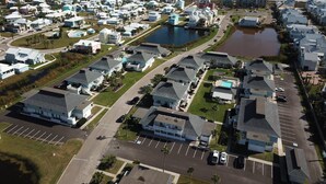Luchtbeeld van een kustgebied met woningen, een strand en een waterlichaam.
