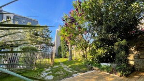 Una terraza de madera con un sendero de piedra que lleva a una casa.