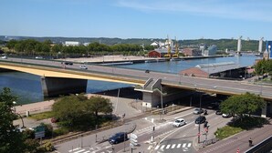 A bridge over a river with a cityscape in the background. - LUMINOUS COMFORT CALM (Rouen)