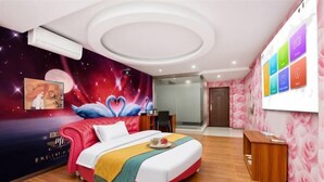Camera d'albergo con un letto, una scrivania, una parete decorata con un murale a tema spaziale e un'area reception.