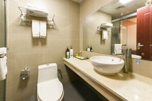 A bathroom with a toilet, sink, and mirror. There are towels and toiletries on the counter. - Sihui Aikeyou Hotel (Sihui Plaza) (Sihui)
