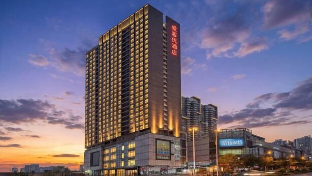 Un hotel di grandi dimensioni con numerose finestre e un cartello ben visibile sulla facciata.