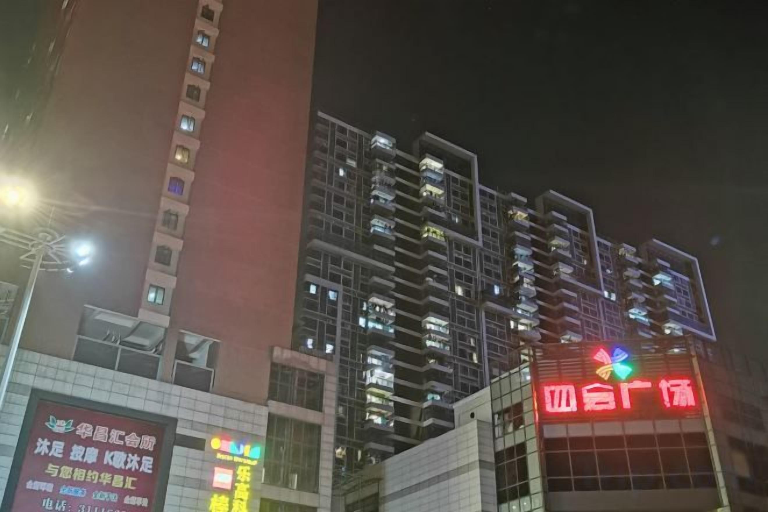 A multi-story building with illuminated signage, likely a hotel or commercial property.