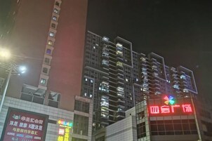 Un edificio de varios pisos con letreros iluminados, probablemente un hotel o propiedad comercial.