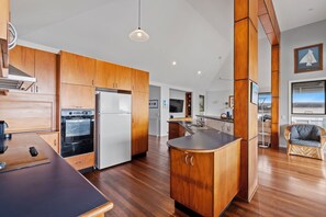 A modern kitchen with wooden cabinets, a built-in oven, and a central island.