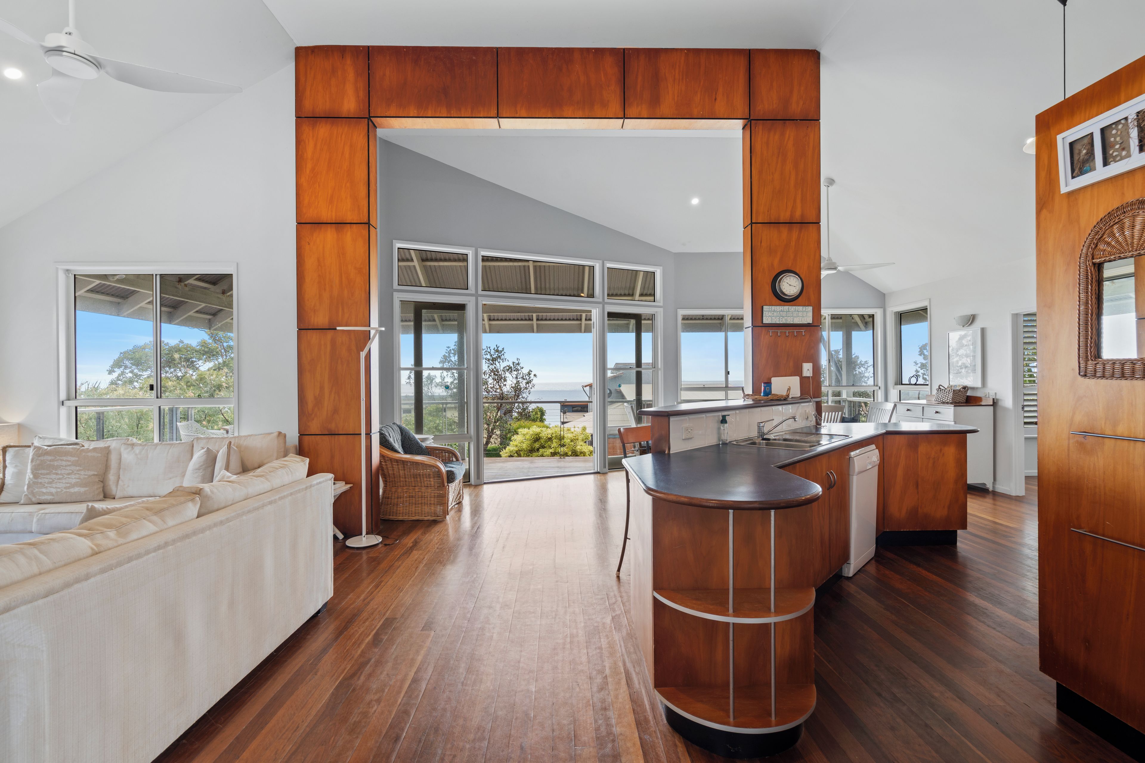 A modern kitchen with a wooden cabinet, a built-in island, and a view of the outdoors.