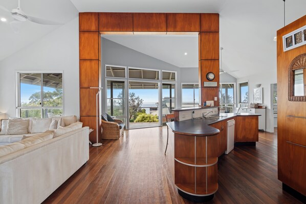 A modern kitchen with a wooden cabinet, a built-in island, and a view of the outdoors.