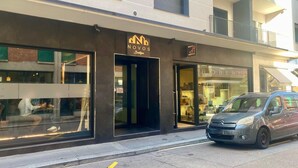 A modern building with a storefront labeled "NOVOS Boutique" and another store named "ROBERTO". - Boutique Apartment 5 (Lugano)