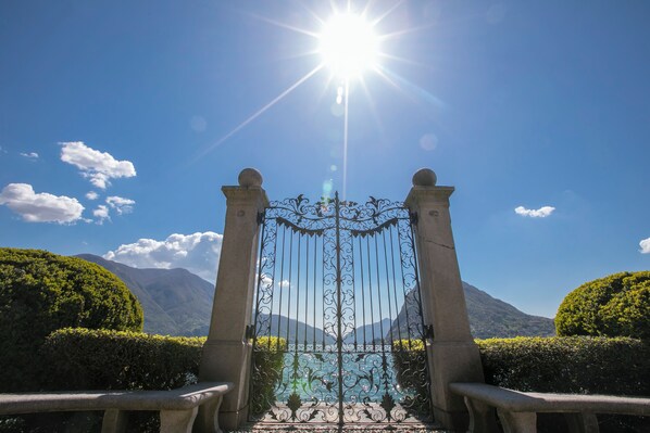 A wrought iron gate leading to a mountainous landscape with a clear sky.