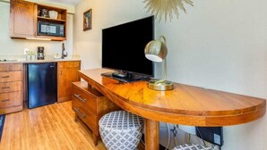 Eine kompakte Küche mit Mikrowelle, Kaffeemaschine und kleinem Kühlschrank.