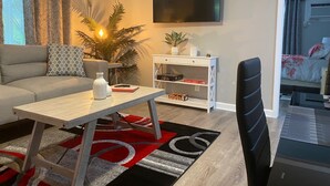 Een moderne woonkamer met een bank, een salontafel, een televisie en een boekenkast.