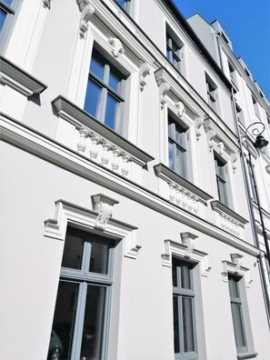 Un bâtiment doté d’éléments architecturaux classiques, notamment des encadrements de fenêtres ouvragés et des moulures décoratives.