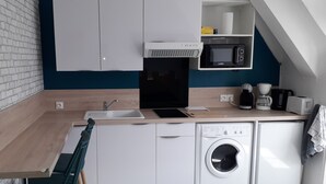 Cocina compacta con lavamanos, microondas, tostadora y lavadora.