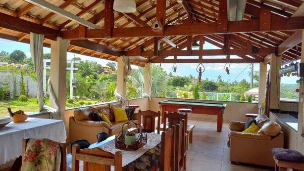 An open-plan living area with a pool table, seating, and a view of greenery.