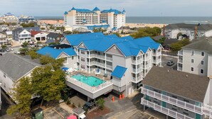 Een meerhoog hotel met een dakterraszwembad en uitzicht op het strand.