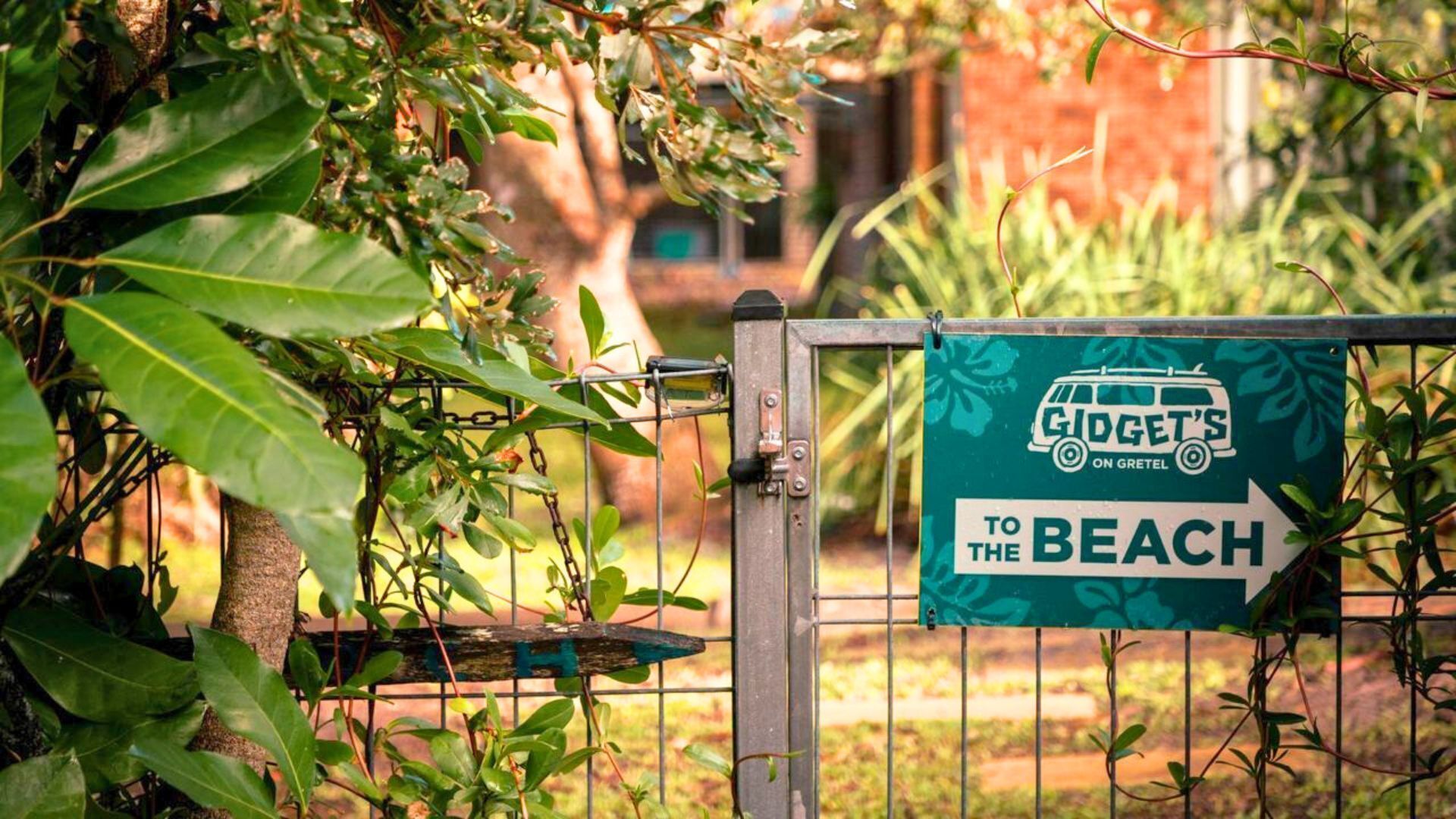Un letrero en un portón dice 'Gidget's On Gretel to the Beach'.