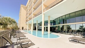 Un espace piscine d’hôtel avec des chaises longues et une grande piscine.