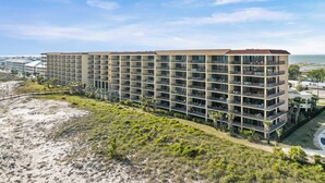 Un hôtel à plusieurs étages doté de balcons, situé près d’une plage.