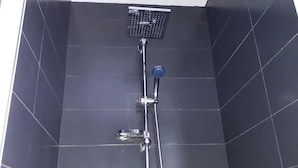 Eine Dusche mit Handbrause und fest installierter Bedienfeld.