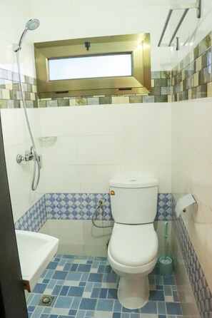 A bathroom with a toilet, a shower, and a bathtub.
