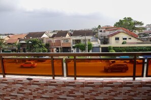 Zona residencial amb cases, un carrer i una vista des d'un balcó.